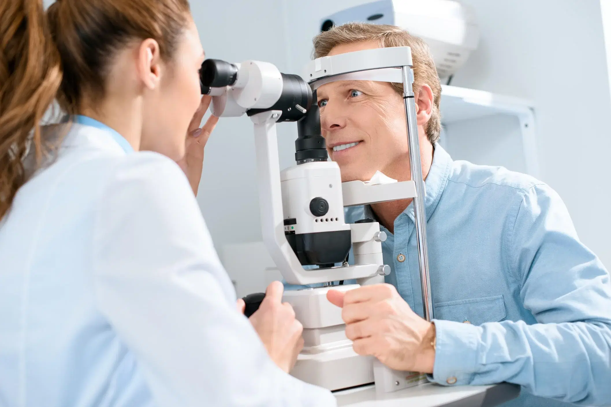 Ophtalmologue examinant les yeux d’un patient à la lampe à fente : offre emploi ophtalmologue en centre d’ophtalmologie